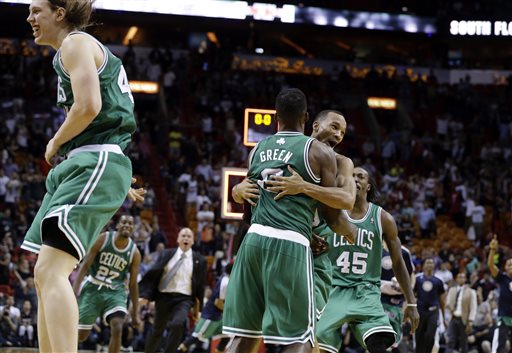 Boston Celtics' Jeff Green is hugged by Avery Bradley after shooting a game-winning three-point basket against the Miami Heat during the second half of an NBA basketball game, Saturday in Miami. The Celtics won 111-110. At left is Celtic's Kelly Olynyk.