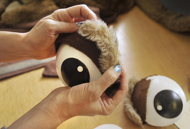 Colleen Writt replaces the eyebrows on a mascot costume undergoing a few repairs at her shop.