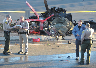 Sheriff’s deputies work near the wreckage of a Porsche that crashed into a light pole on Hercules Street near Kelly Johnson Parkway in Valencia, Calif., on Saturday. A publicist for actor Paul Walker says the star of the “Fast & Furious” movie series died in the crash north of Los Angeles. He was 40.