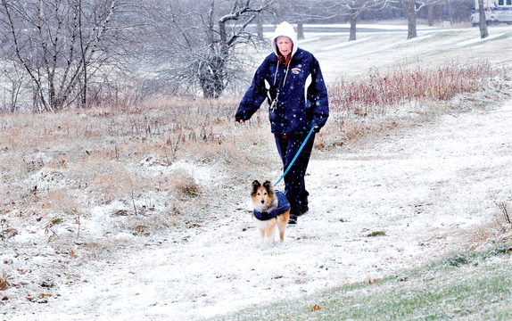 Staff photo by David Leaming WINTER WALK: Candice Hinckley and her dog Marx went for a walk on a snow covered trail in Waterville as snow fell most of the day on Sunday, Dec. 1, 2013.
