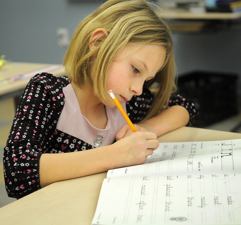 CURSIVE: Chelsea Elementary third-grader Chloe Smiley works on a cursive lesson during a recent class.