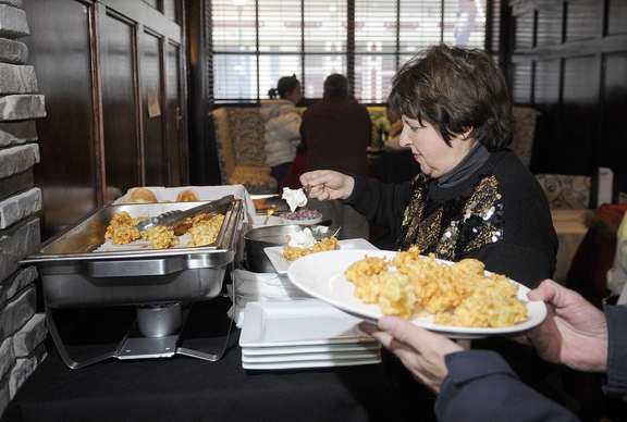 TIS THE SEASON: Susan Montell prepares a plate during the fifth annual latke festival at Alex Parkers Steakhouse in Gardiner on Sunday. The annual gathering open to the public celebrates the Jewish holiday of Hanukkah.