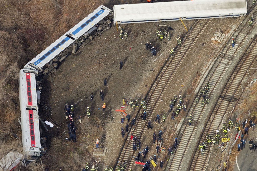 Emergency rescue personnel work the scene of a Metro-North passenger train derailment in the Bronx. The train derailed on a curved section of track on Sunday morning, coming to rest just inches from the water.