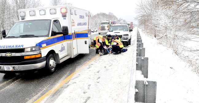 SLIP SLIDING: Emergency workers prepare to transport an injured person after a pickup truck collided with a car in the southbound lane of Interstate 95 in Waterville on Monday.