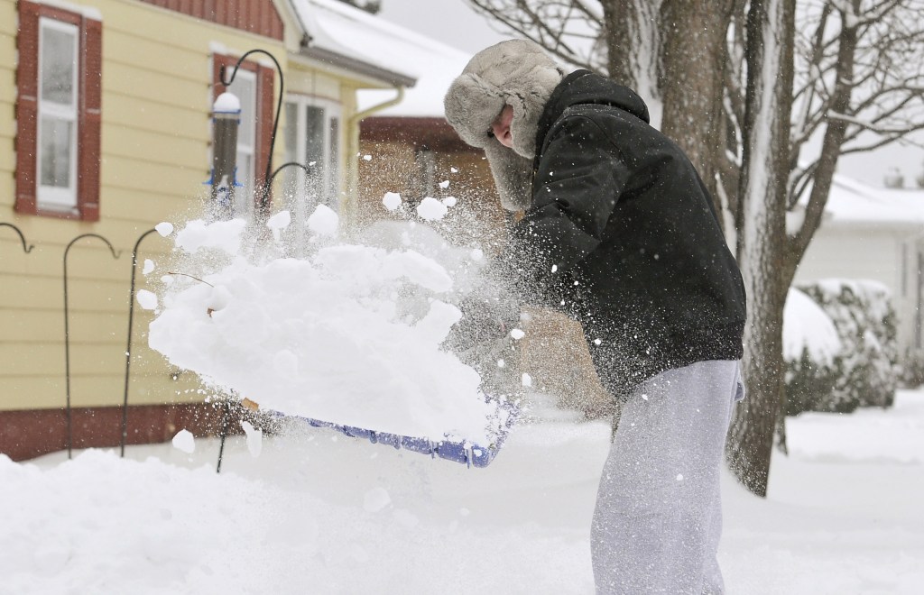 Andrew Wooster clears off his driveway in Virginia, Minn. Tuesday. The storm is due in part to the jet stream dipping south, allowing frigid arctic air to rush in.