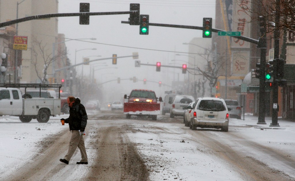 Cars and pedestrians creep along slick, snow-covered streets on Tuesday in downtown Casper, Wyo. Winter storm warnings and advisories had been posted for all but the extreme western part of the state Tuesday.