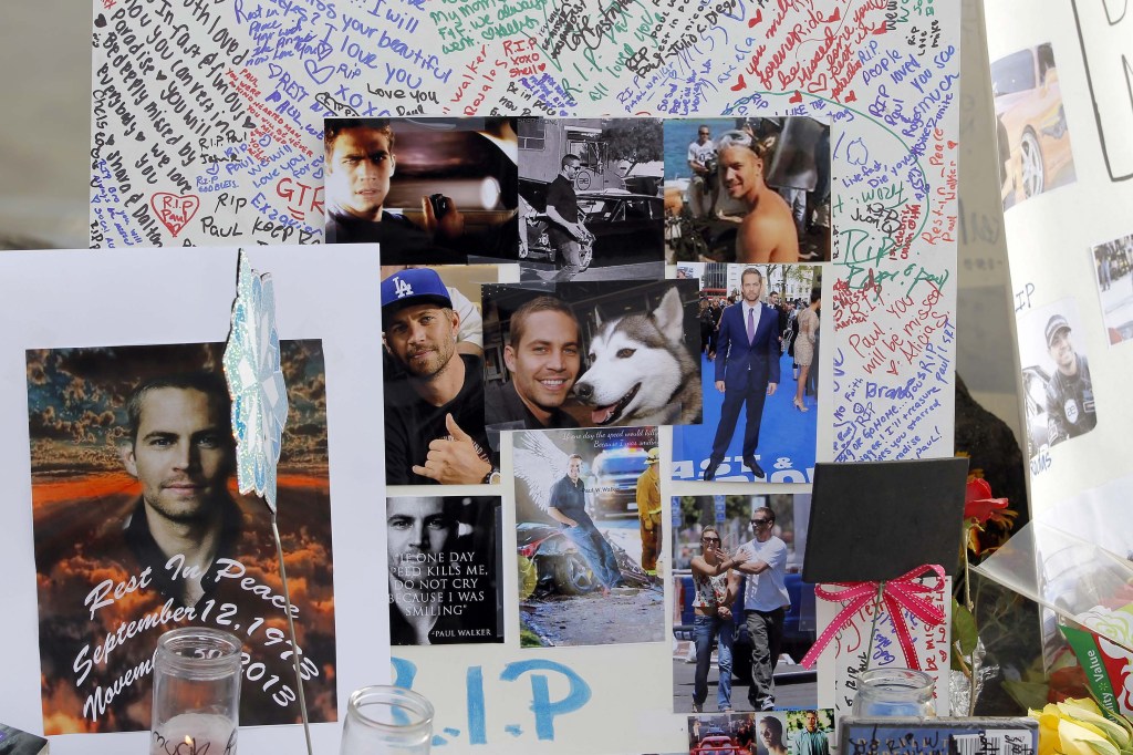 Photos and messages are seen at a roadside memorial on Monday at the site of the Saturday auto crash that took the life of actor Paul Walker and another man in the small community of Valencia, Calif..