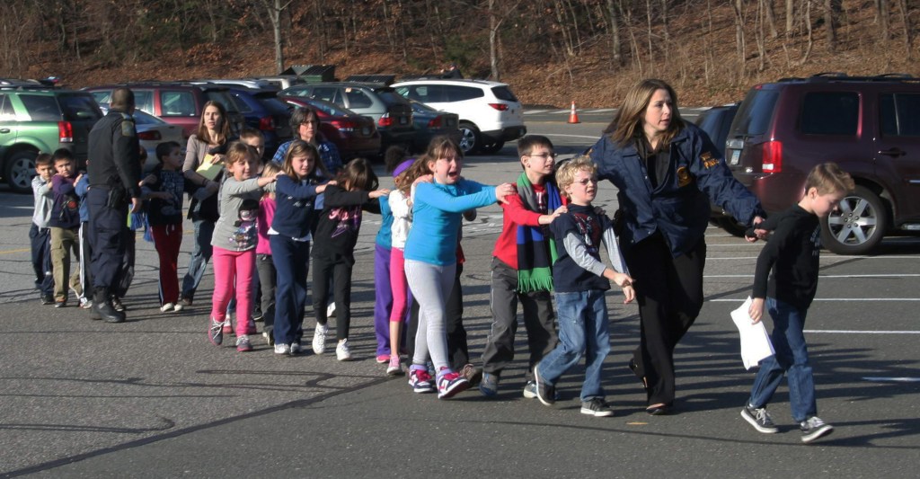 In this photo provided by the Newtown Bee, Connecticut State Police lead a line of children from the Sandy Hook Elementary School in Newtown, Conn. on Friday, Dec. 14, 2012 after a shooting at the school. Recordings of 911 calls from the Newtown school shooting are being released Wednesday Dec. 4, 2013, days after a state prosecutor dropped his fight to continue withholding them despite an order to provide them to The Associated Press.