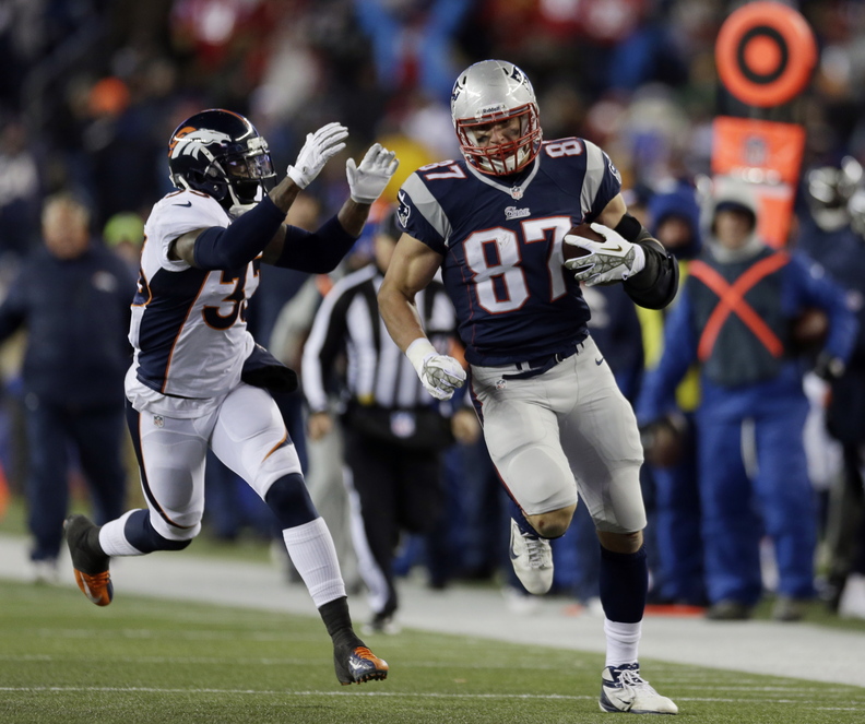 New England Patriots tight end Rob Gronkowski (87) runs from Denver Broncos safety Duke Ihenacho (33) after a catch in the third quarter of an NFL football game Sunday, Nov. 24, 2013, in Foxborough, Mass. (AP Photo/Steven Senne)