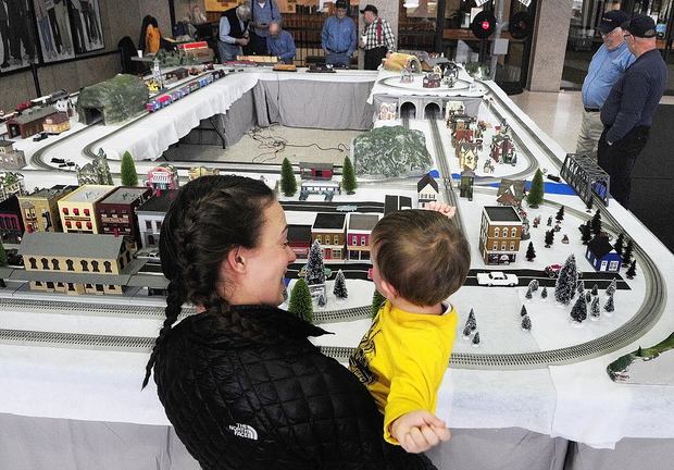 TRAIN GANG: Michelle Mosher and her son Alex Pelotte, 2, of Waterville, watch model trains go around the tracks Friday at the Maine State Museum in Augusta. The model railroad displays will be up and the museum will open free of charge from 10 a.m. to 3 p.m. today. The Great Falls Model Railroad Club and the Maine 3-Railers have set up and will operate a variety of displays running G, HO and O-gauge model trains and accessories. Go to kj.online for a video of the trains.