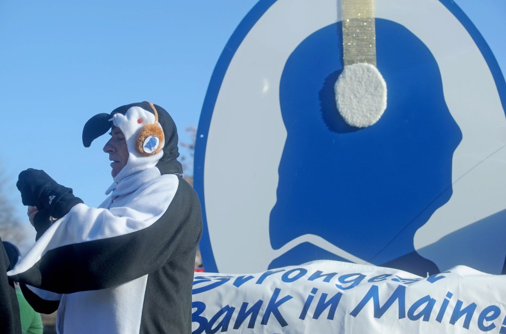 Celebration: Peter Judkins, president of Franklin Savings Bank, takes a picture while dressed like a penguin at the annual Chester Greenwood Day parade in downtown Farmington on Saturday.