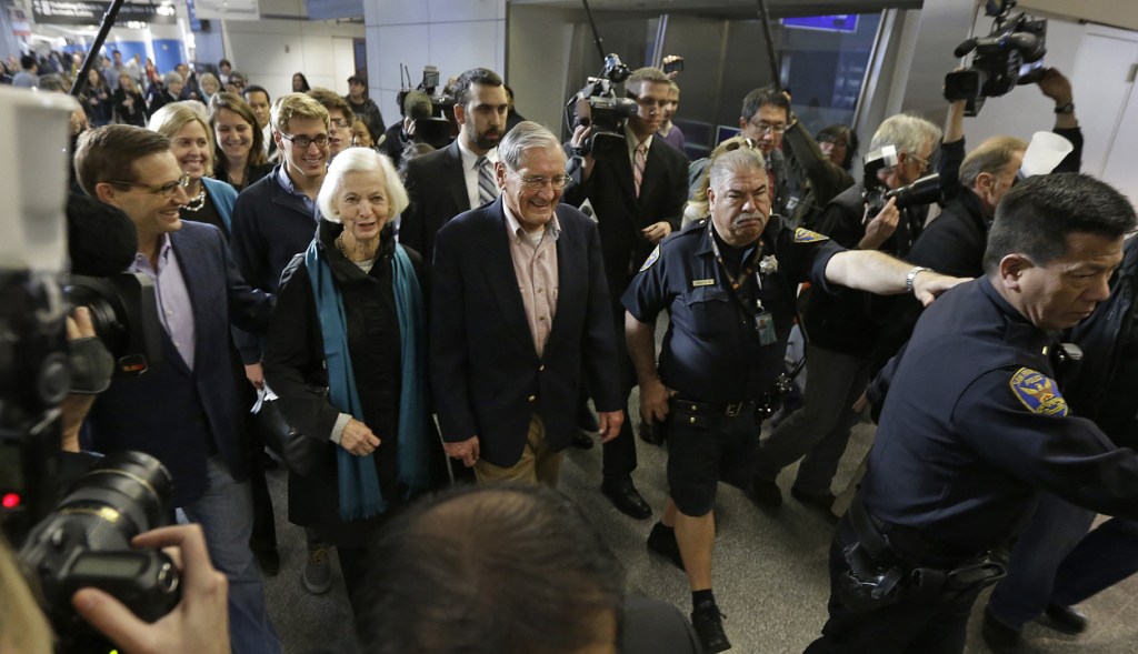Merrill Newman, center, walks beside his wife, Lee, and his son Jeffrey, left, after arriving at San Francisco International Airport on Saturday. Newman was detained in North Korea late October at the end of a 10-day trip to North Korea, a visit that came six decades after he oversaw a group of South Korean wartime guerrillas during the 1950-53 war.