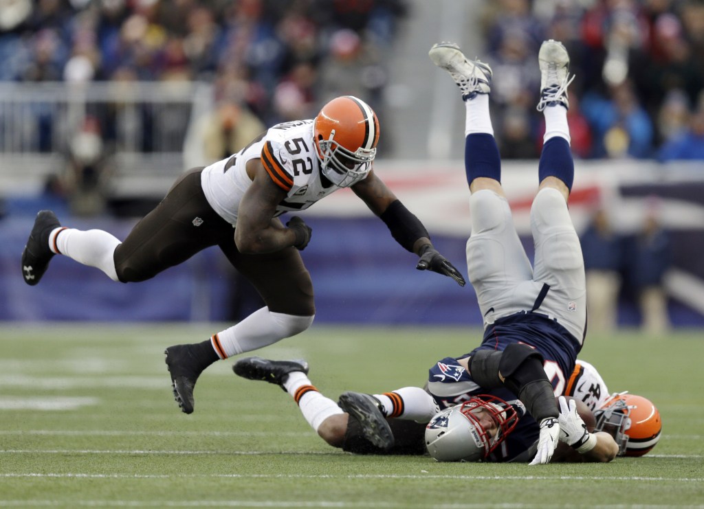 Cleveland Browns safety T.J. Ward (43) and linebacker D’Qwell Jackson (52) tackle Rob Gronkowski of the Patriots after a catch in the third quarter Sunday at Foxborough, Mass. Gronkowski hurt his leg on the play and was carted to the locker room.