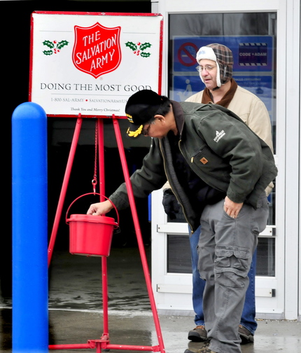 THANK YOU: Salvation Army volunteer Peter Wilson, right, watches as Jeff Cuares donates in Waterville earlier this week.