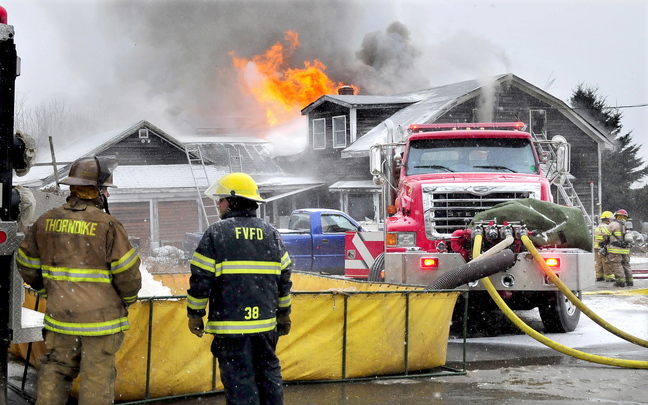Portable Reservoir: Firefighters from Thorndike and Freedom unload water from a truck to a portable reservoir to extinguish a stubborn wind-blown fire at a home on Aborn Hill Road in Knox on Monday.