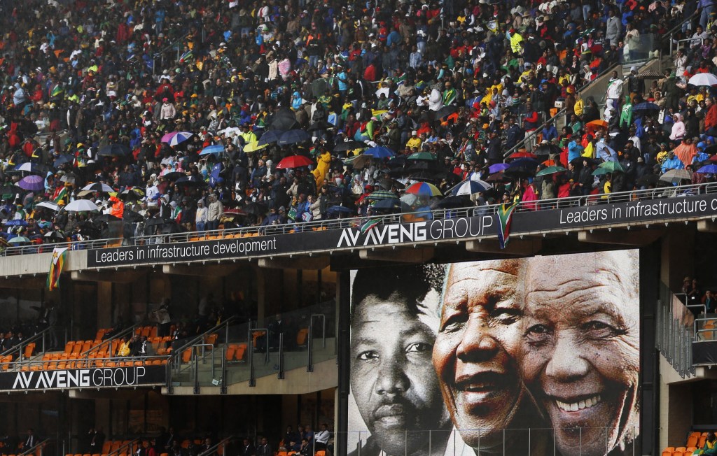 Faces of Nelson Mandela through the ages are shown on a big screen during the memorial service for former South African president Nelson Mandela at the FNB Stadium in Soweto, near Johannesburg, South Africa, Tuesday.