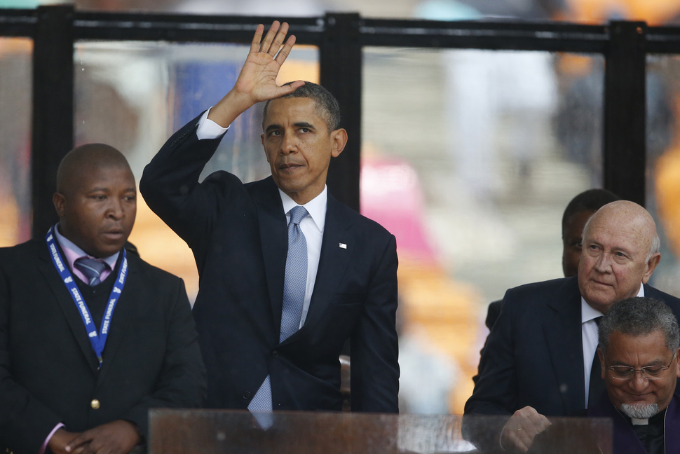 South Africa’s last apartheid-era president, F.W. de Klerk, right, looks over as President Barrack Obama waves to mourners after speaking at the memorial service for former South African president Nelson Mandela at the FNB Stadium in Soweto near Johannesburg on Tuesday.