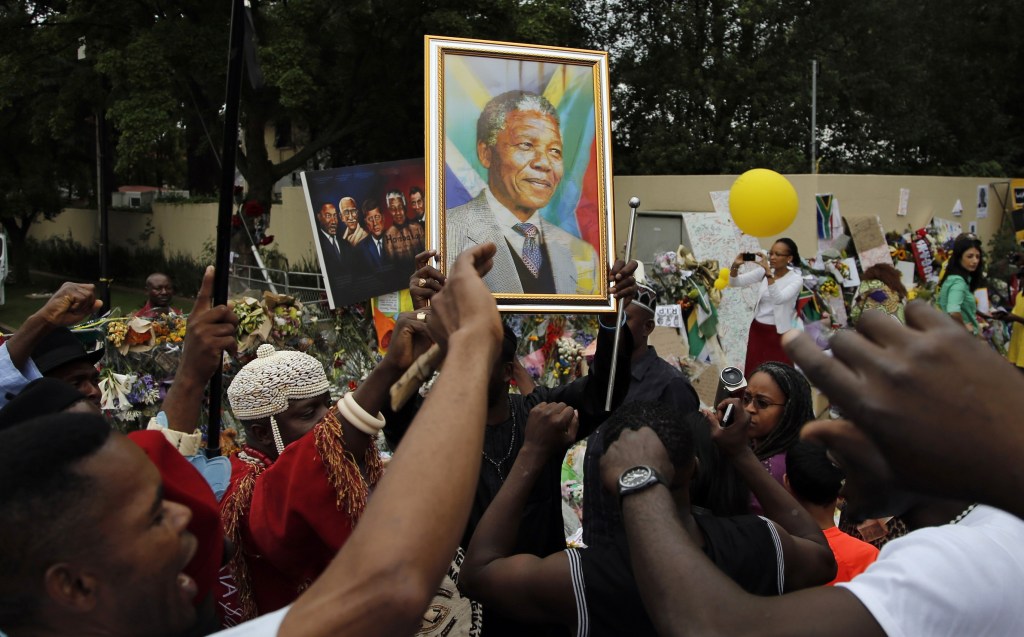 Mourners from Nigeria sing outside the home of Nelson Mandela in Johannesburg, South Africa, Monday. Tens of thousands are expected to attend the memorial service that is being staged in memory of the beloved leader.