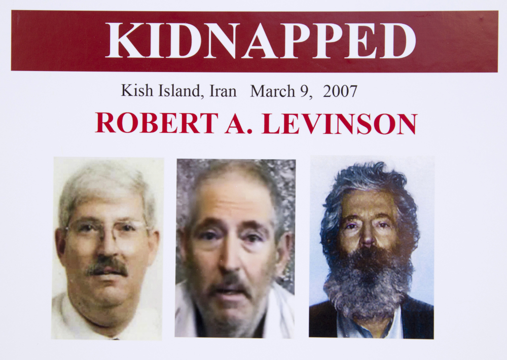 An FBI poster showing a composite image of retired FBI agent Robert Levinson, right, of how he would look like now after five years in captivity, and an image, center, taken from the video, released by his kidnappers, and a picture before he was kidnapped, left, displayed during a news conference in Washington, on March 6, 2012.