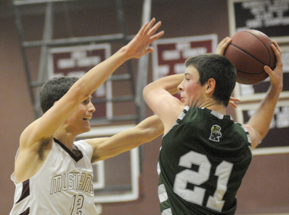 Staff photo by Andy Molloy OPEN ARMS: Monmouth Academy's Brett Wilson, left, attempts to block a pass Thursday by Winthrop High School's Matt Sekerak during a basketball match up in Monmouth.