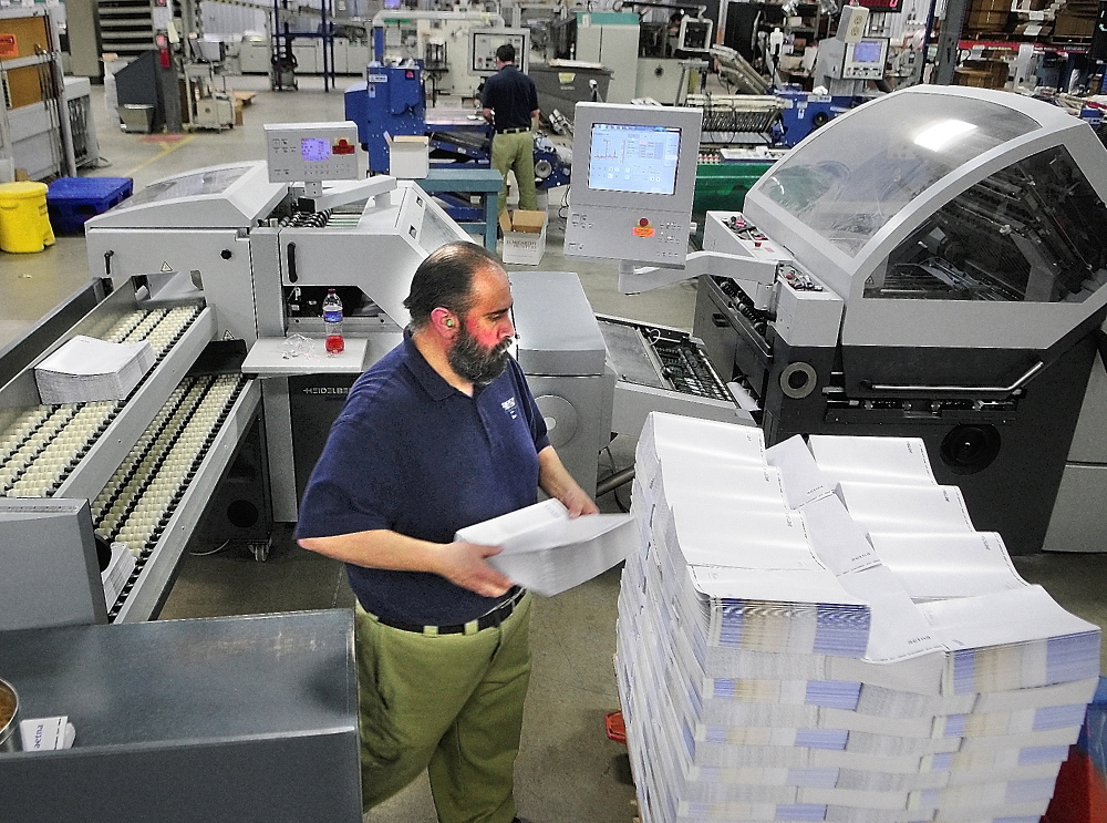 Health care: Folder operator Reno Cyr works on Thursday at J.S. McCarthy Printers in Augusta.