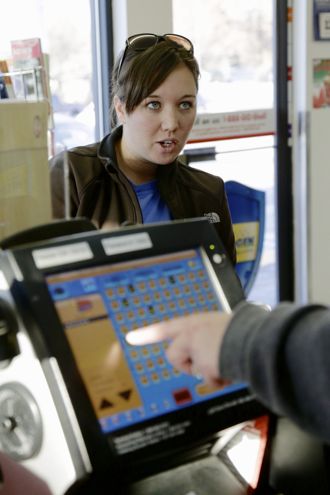 Customer Staci McDonnell dictates her Mega Millions numbers to a store clerk as she purchases lottery tickets at the Speedee Mart convenience store in Gretna, Neb., Thursday, Dec. 12, 2013, where someone bought a multi-million dollar winning Powerball lottery ticket from the previous day’s drawing. Lottery officials behind Mega Millions say the lesser known game alongside Powerball, is grabbing some attention with an estimated $400 million jackpot for Friday’s drawing that comes less than two months after a major revamp to the game.