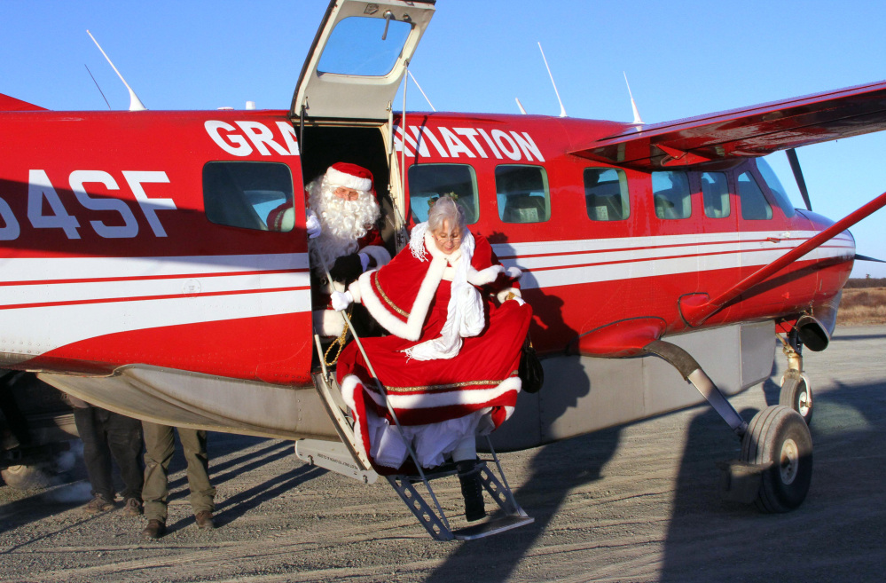 Santa and Mrs. Claus get off a small airplane to visit the children in Kwethluk, Alaska. AP Photo