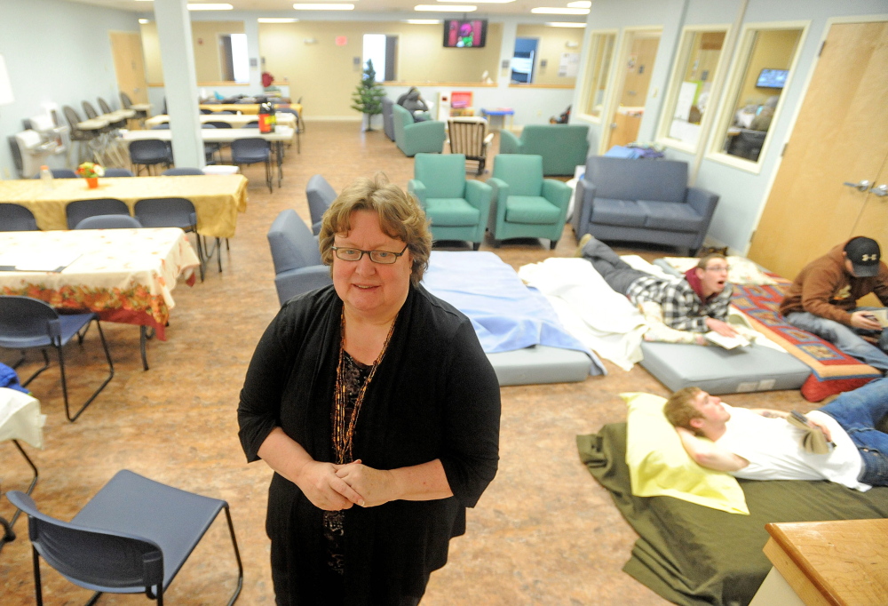 filled: Betty Palmer, executive director of the Mid-Maine Homeless Shelter in Waterville, stands in the day room that doubles as an over-flow sleeping area when the shelter is at or above capacity. Some people were already using the space Friday and Palmer expected the shelter to be over-flowing with the onset of a bitter cold snap.