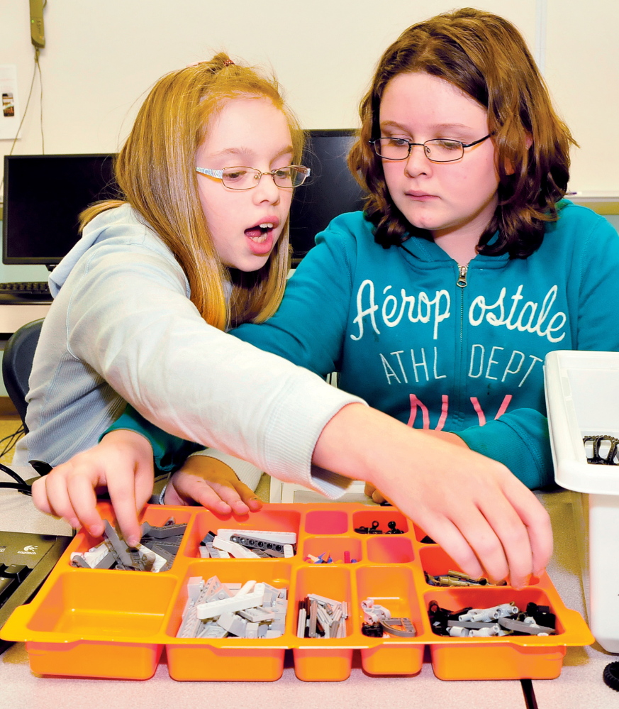 ON LEGO: Clinton Elementary School students Amber Wescott, left, and Haley Trahan select Lego pieces to construct one of Santa’s reindeer during a project at the school this week.