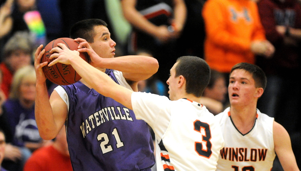 HIGH SCHOOL BASKETBALL: Winslow High School’s Trevor Lovely, 3, center, tries to steal the ball from Waterville Senior High School’s Chris Hale, 21, in the first quarter in Winslow on Saturday. Winslow’s Connor Wildes, 12, is seen in the background.