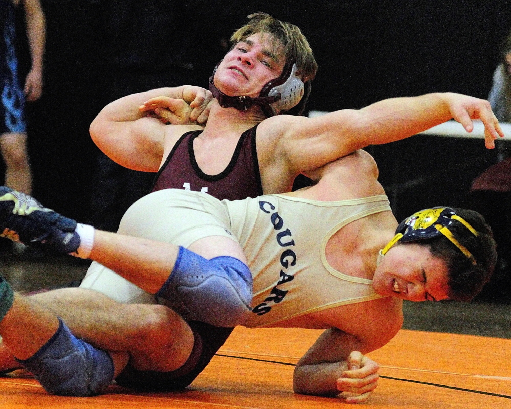 Monmouth Academy’s James Gambino, top, and Mount Blue’s Danny Reed compete in a 138-pound championship semi-finals during the Tiger Invitational on Saturday December 14, 2013 in the John A. Bragoli Memorial Gym in Gardiner.