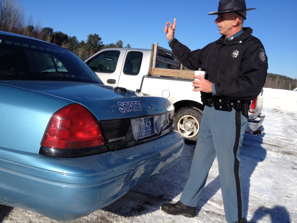 Trooper Sam Tlumac inspects his cruiser Monday morning after it was rear-ended on Route 202 in Manchester. Tlumac was assisting a motorist around 10 a.m. when a pickup struck the rear of his vehicle while it was parked on the side of the road. No injuries were reported. The state cruiser was a loaner after Tlumac’s primary vehicle was destroyed when it was rear ended Dec. 1 in Pittsfield. State law requires motorists to move over one lane when passing troopers and other emergency vehicles parked on the side of the road.