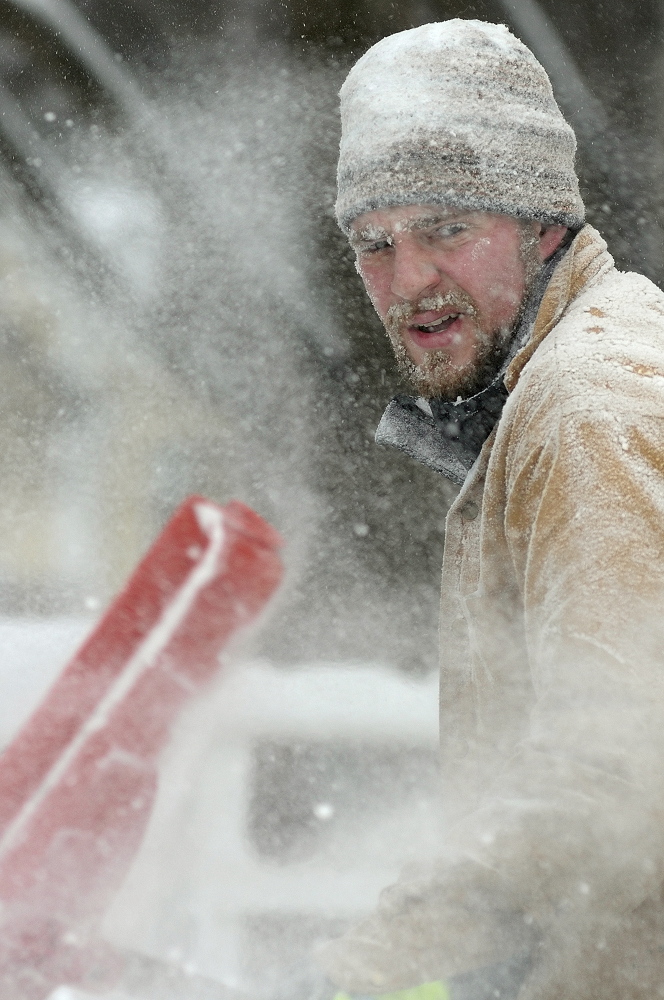SNOW FACE: Zachary Morse’s face and clothes are coated with snow while he shovels out the Unitarian Universalist Community Church on Sunday in Augusta. Morse is the plowing contractor for the church, which canceled its services earlier in the day because of the storm.