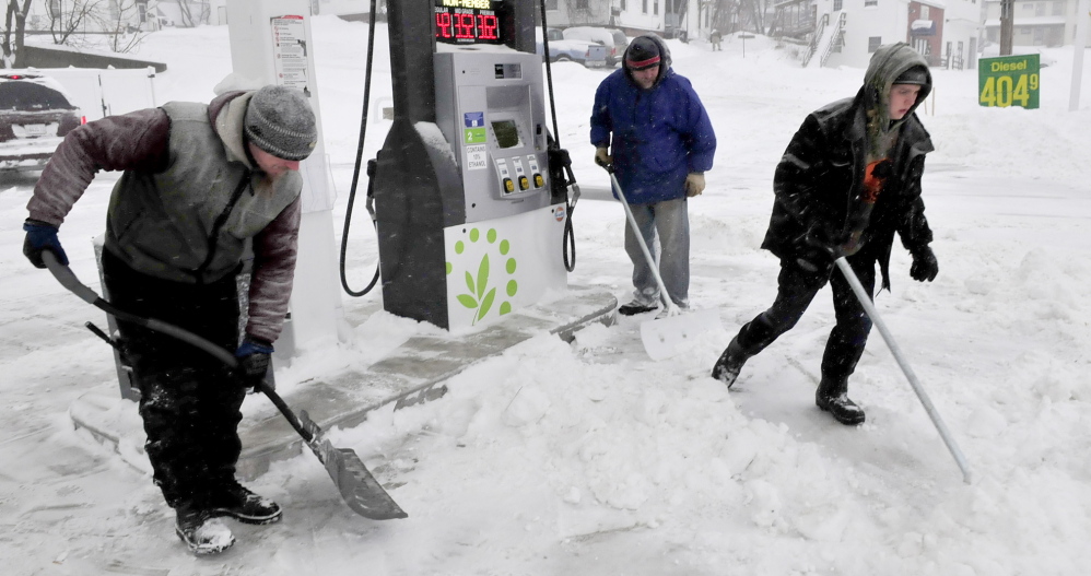 BUSY: Workers with Goodall Landscaping company kept busy shoveling and plowing during the snowstorm on Sunday. Cleaning up around gas pumps at the Cumberland Farms store in Waterville are, from left, Chris Loder, Frank Condon and John Wilcox.