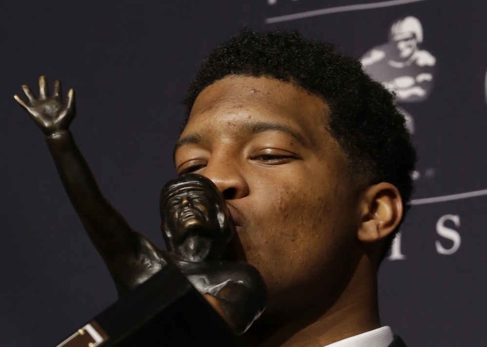 KISSING HIS REWARD: Florida State quarterback Jameis Winston kisses the Heisman Trophy while posing for photographers after winning the trophy, Saturday in New York. Winston, 19, is the youngest winner of the trophy and the second straight player to win the prestigious award in his first year of college.