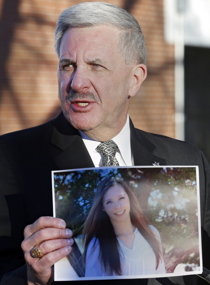 Arapahoe County Sheriff Grayson Robinson holds a picture of Claire Davis the 17-year-old student that was shot during a briefing Saturday at Arapahoe High School in Centennial, Colo. Davis was shot by 18-year-old shooting suspect Karl Halverson Pierson at the school on Friday before he took his own life.