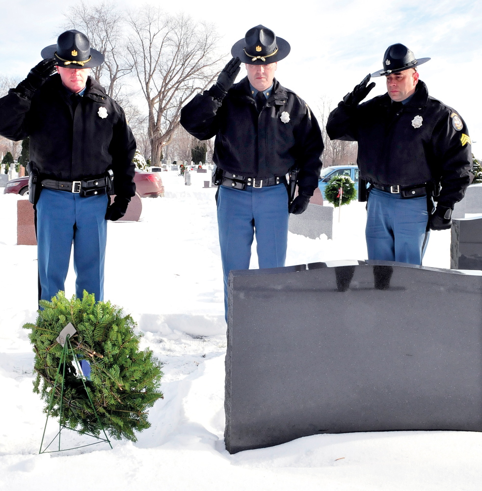PAYING RESPECT: Maine State Police troopers salute at the gravesite of Trooper Jeffrey Parola at St. Francis Cemetery in Waterville after placing a wreath on it Tuesday. Troopers who have died in the line of duty were recognized at other cemeteries as well. From left are Lt. Scott Ireland, Maj. Gary Wright and Sgt. Mike Zabarsky.