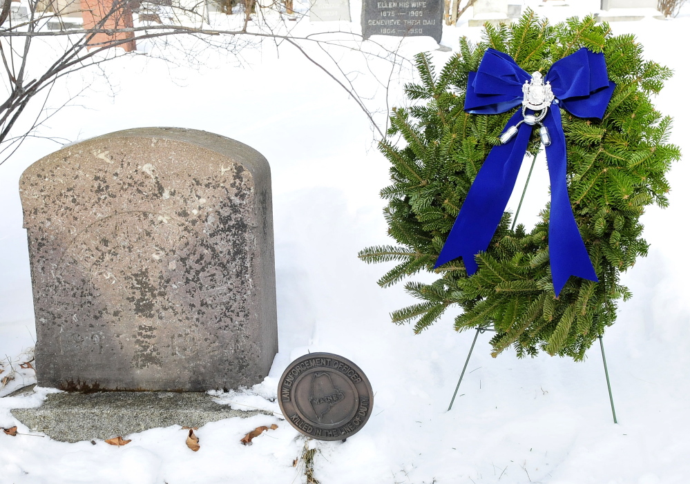 FIRST FATALITY: The gravesite of Trooper Emery Gooch was cleared and a wreath placed on it by fellow troopers at the Pine Grove Cemetery in Waterville on Tuesday. Gooch was the first officer of the Maine State Police to die in the line of duty, in 1924.