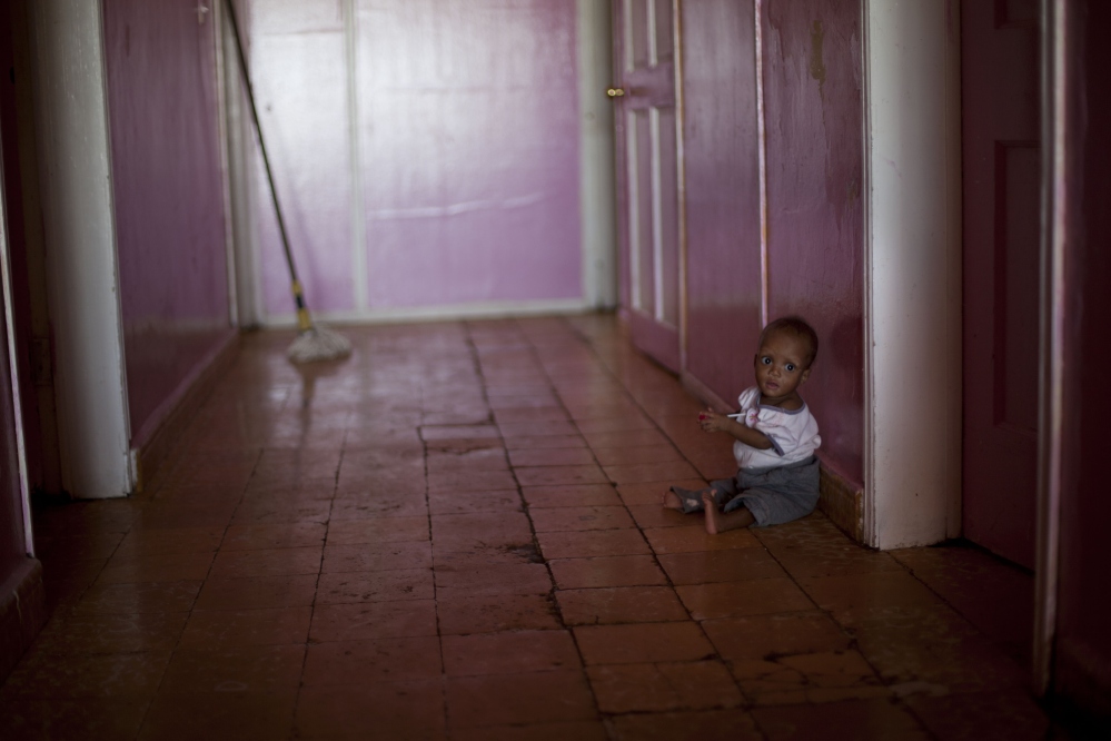 Ten-month-old Martelly Jean Louis sits alone on the floor of the U.S.-based Church of Bible Understanding orphanage in Kenscoff, Haiti. The orphanage is run by a Christian missionary group funded by the Olde Good Things antique store on Manhattanís Upper West Side.