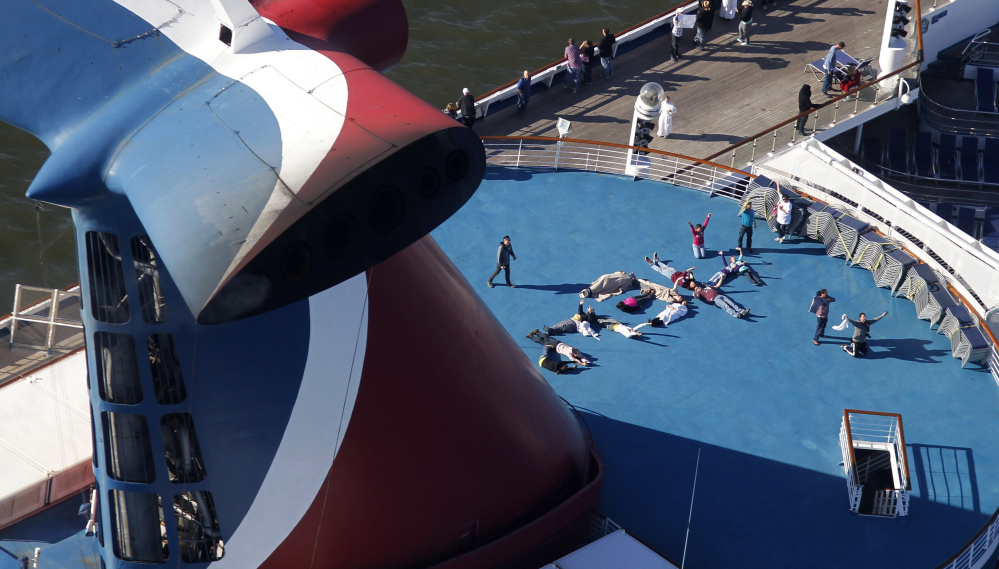 Passengers spell out the word “HELP” aboard the disabled Carnival Lines cruise ship Triumph as it is towed to harbor off Mobile Bay, Ala., in this Feb. 14, 2013, photo.