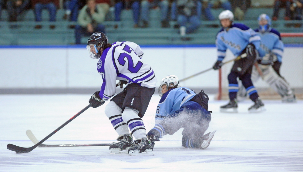 Waterville Senior High School’s Christopher Lee, 27, skates after the puck as Westbrook High School’s Dylan Francoeur, 16, in the first period at Colby College on Thursday.