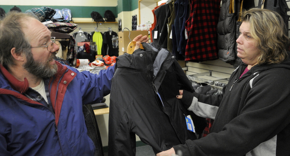 AHEAD OF THE ICE: Jay Lewis discusses the merits of a jacket Friday with his wife, Tracy, at Renys in Gardiner. The couple made a hasty holiday shopping trip in the morning, before having snow tires put on their car in the afternoon in anticipation of an ice storm forecast for this weekend.