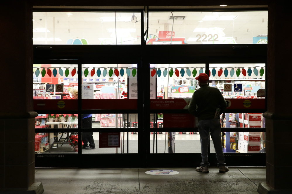 A shopper waits outside a Kmart store for it to open in Anaheim, Calif., on Thanksgiving night. Some retailers, disappointed by sales so far during the holiday shopping season, are staying open for several straight days, starting this weekend.