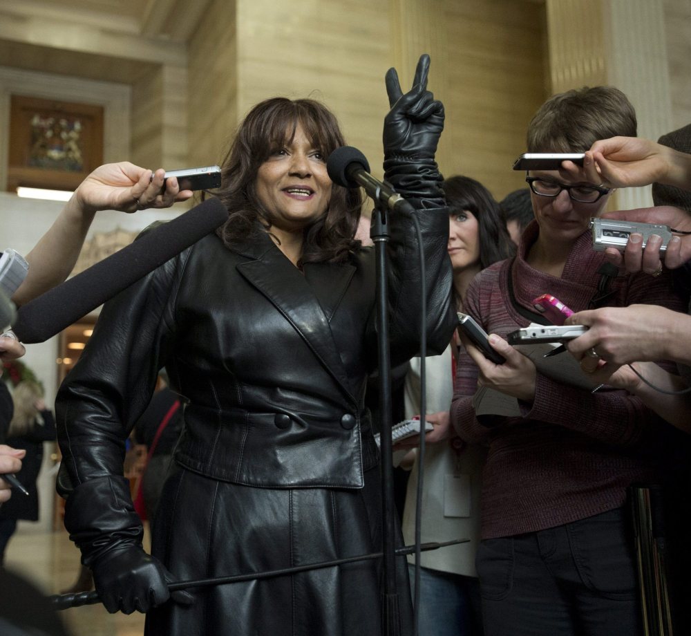 Terri-Jean Bedford, a retired dominatrix, gives a victory sign as she talks to reporters at the Supreme Court of Canada in Ottawa on Friday morning.