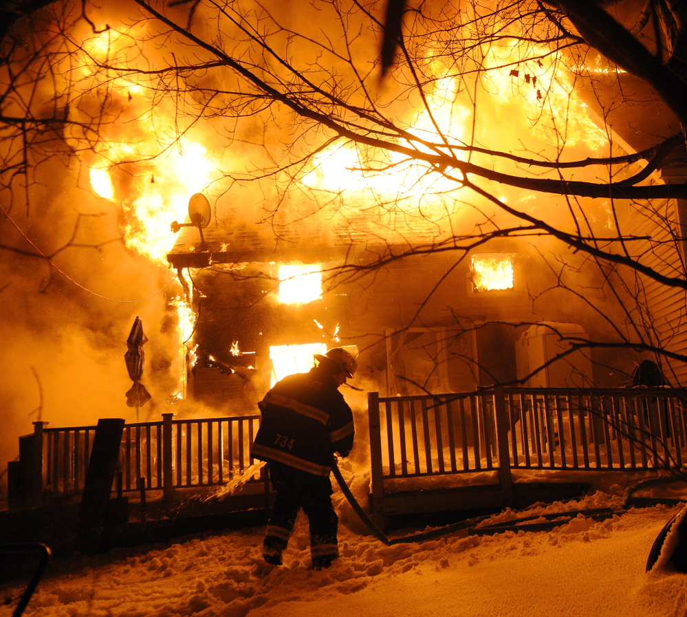 BURNING BRIGHT: A firefighter attempts to extinguish a blaze Friday that destroyed a home on Northern Avenue in Gardiner. No injuries were reported, according to firefighters.