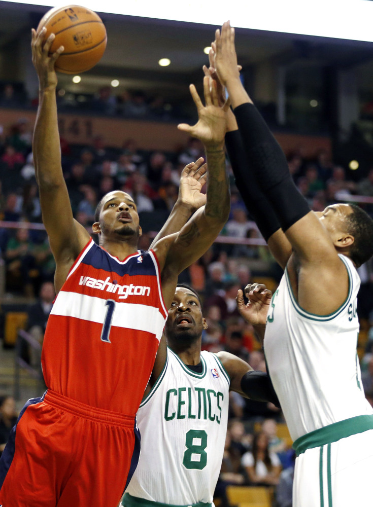 BIG GAME, BIG RALLY: Washington’s Trevor Ariza, left, shoots against Boston’s Jeff Green, center, and Jared Sullinger in the first quarter Saturday in Boston. Ariza scored 27 points and the Wizards beat the Celtics 106-99.