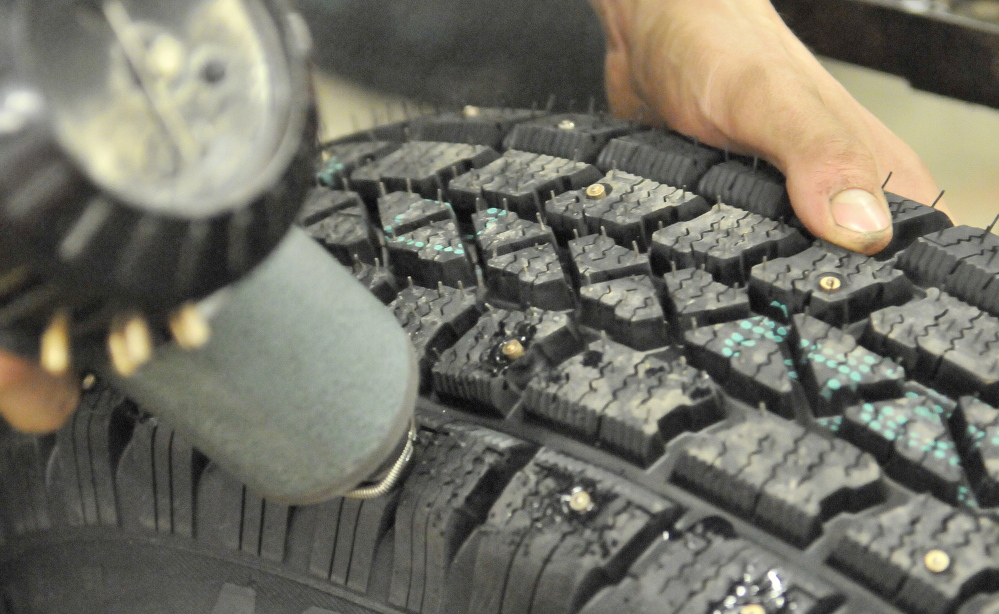 Preparations: Leland Bradford, 18, installs metal studs to snow tires at VIP in Waterville on Saturday to stay ahead of the demand this winter. VIP has seen an increase in studded snow tire sales as people gear up for Sunday’s predicted ice storm.