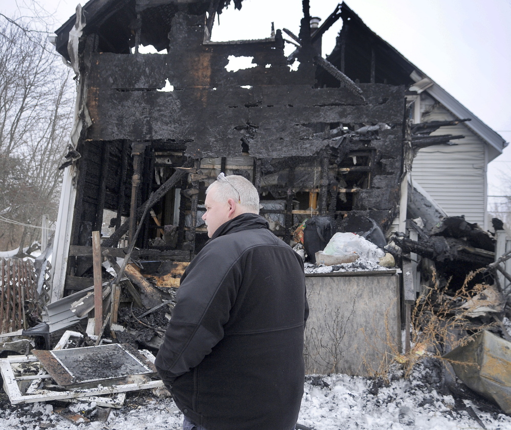 AFTERMATH: Investigator Ken MacMaster, of the Office of State Fire Marshal, inspects a Gardiner home Saturday that was damaged heavily by fire the night before. Investigators and Farmingdale firefighters were attempting to determine a cause of the blaze.