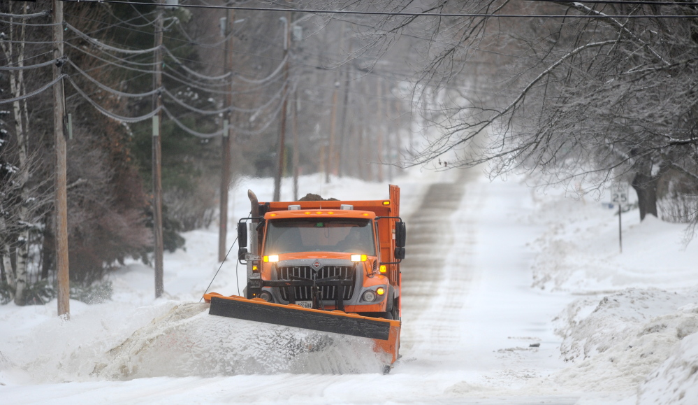 ICEY DICEY: A snowplow clears Mayflower Hill Drive in Waterville as a major ice storm rolls through the state on Sunday morning.