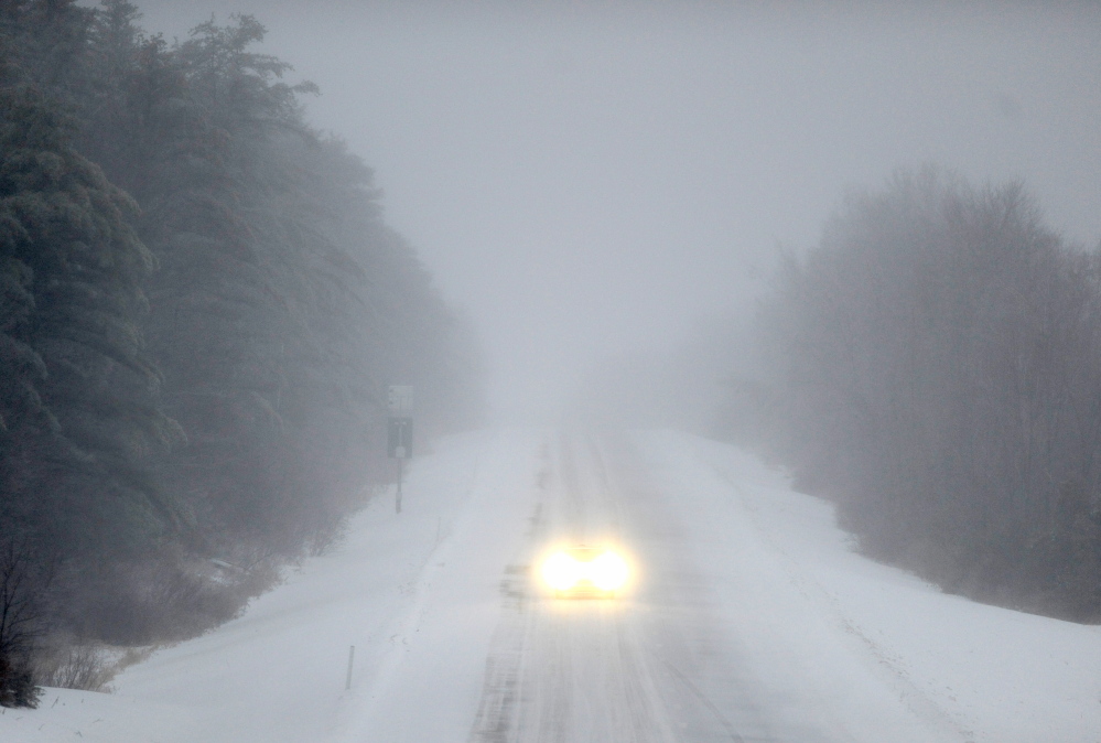 ICEY DICEY: A lone car drives north on Interstate 95 in Waterville as a dangerous wintry mix of ice and snow falls on Sunday morning.